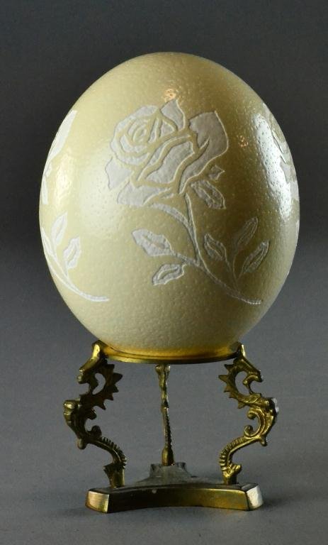 Ostrich Egg Etched with Floral Design: Hollow egg etched on all sides with rose design, signed Donna Loveless, dated Sept. 2001, 6" H,along with brass stand, excellent condition.