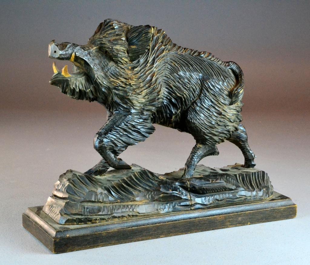 A Fine Wood Carving Depicting A Boar: Carved in the Black Forest style, depicting a standing wild boar, with fierce teeth, on a naturalistic base 15" L x 11" H, not including the base. Circa early to mid 20th century.