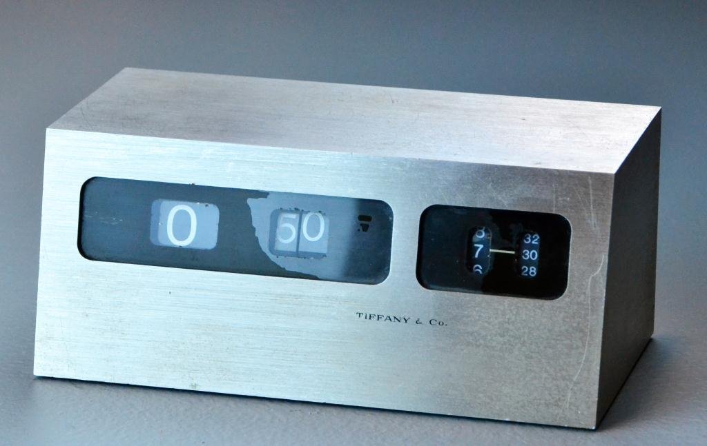 Tiffany & Co. Brushed Steel Modern Clock: Retro desktop clock with rolling numbers for time, circa mid-20th century, 3" H x 6.75" L, surface wear commensurate with age.