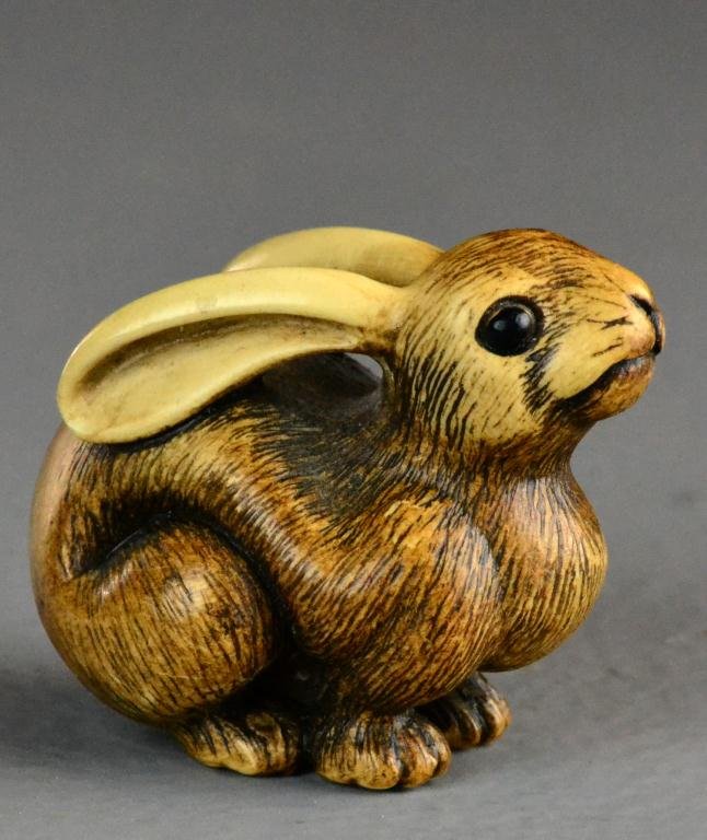Japanese Carved Ivory Netsuke Meiji Period: Carved to depict a seated rabbit with glass or stone eyes, signed to the backside, very well carved, circa early 20th century. Private collection Flint Mi.