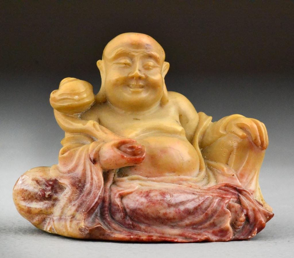 Chinese Qing Carved Soapstone Figure: Finely carved to depict a seated Buddha holding a ruyi scepter, his robes flowing down in mottled red color, 2.75"H X 3.75"W, circa late 19th century. property of a gentleman.