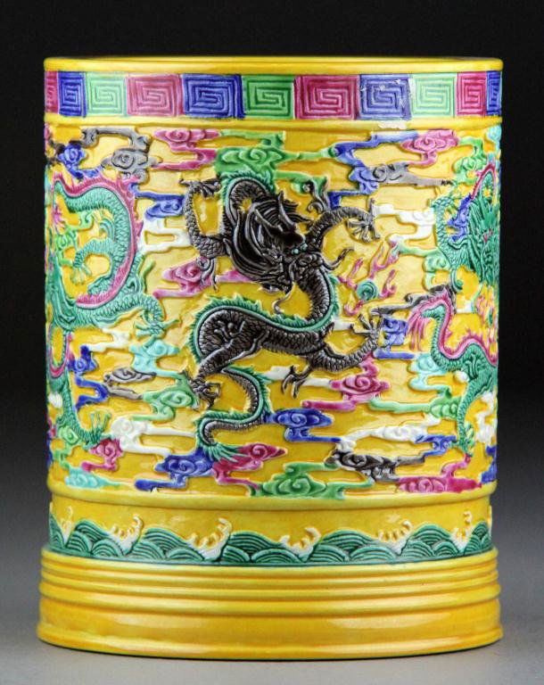 Chinese Famille Rose Porcelain Brush Pot: Of cylindrical form brightly enameled depicting dragons among ruyi clouds all against a yellow ground the base with incised seal mark for "The Great Qing Qianlong Production" 6"H early 20th century.