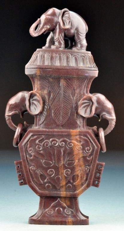 Chinese Qing Carved Agate Vase and Cover: Depicting the face of the beast and stiff petals, with two elephant head handles hung with loose rings, the lid with eloquent finial, with two archaic flanges to the lower side, 8.25" H. Condition: wi