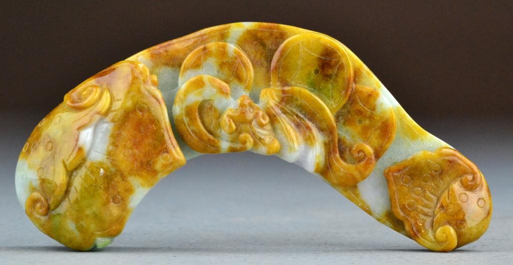 Chinese Qing Carved Jade Buckle: Of naturalistic form, carved to depict bats and coins, the stone with russet inclusions, measures 6"L. Property of a Holly MI Gentleman.