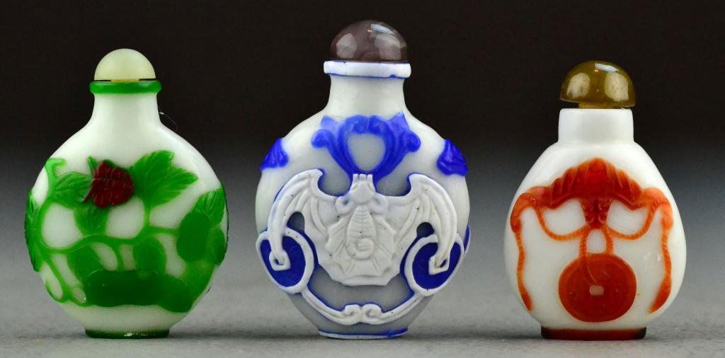 (3) Chinese Peking Glass Snuff Bottles: To include three snuff bottles, two of which are finely molded to depict bats, together with a third example molded to depict insects amongst foilage and a gourd, two bottles lacking spoons, largest i