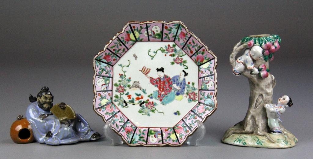 (3) Pcs. Chinese Porcelain Items Incl. Mudman: Consisting of reclining mudman with 5 bats and a fan with embossed marking on bottom, possibly Qing, an octagonal enamelled plate with figures waving a flag (applied red seal on bottom) along with por