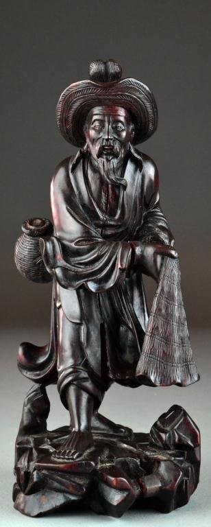 Antique Chinese Wood Carved Figure: Finely carved to depict a fisherman wearing a basket and hat, holding his net, with a wonderful old surface, appears to be signed to the base, 12" H Circa early 20th century Condition with age splits 