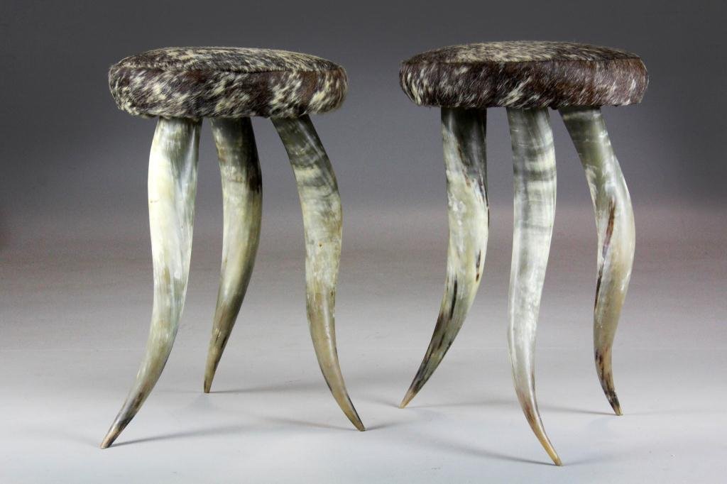 Pair of Cowhide and Longhorn Western Stools: Each stool is covered with cowhide and raised on three longhorn cattle horns, 24" H x 15.5" Diameter, circa 20th century, good condition.