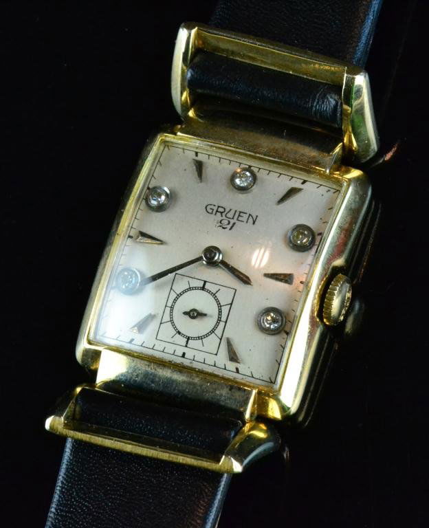 Antique Gruen 14K Gold And Diamond Watch: Classic with 21 jewels, five diamond markers on dial, with black leather strap, circa 1930's to 1940's, excellent condition.