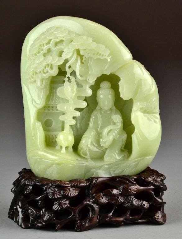 Chinese Carved Celedon Jade Boulder: Depicting a seated Buddha with scepter and smoking censer and tree and crane en verso, with reticulated carved wood stand, circa 19th-early 20th century, 5.25" H without stand, excellent condition. Pr