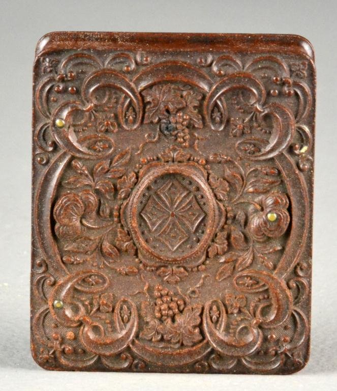 Dagurreotype Of a Gentleman In Gutta Percha Case: Depicting the head and torso of a young bearded man with coat and tie, oval dagurreotype encased in gilt liner, gutta percha case with carved flora and fauna, 3" H x 2.5" W. Circa mid 19th century.