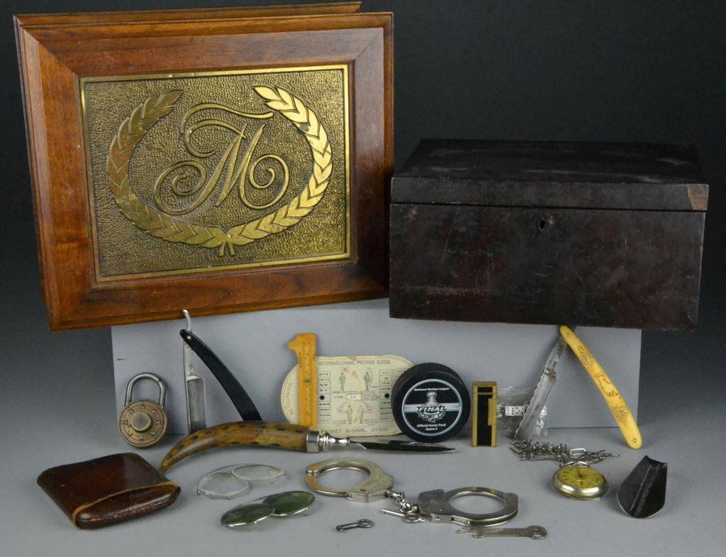 (20+) Antique Gentlemen's Lot: To include two wooden boxes, and two banks, handcuffs with leather case, leather cigar case, clip on sunglasses, Stanley Cup hockey puck and Dunhill Lighter, largest is 13" L, 20th century, good condi