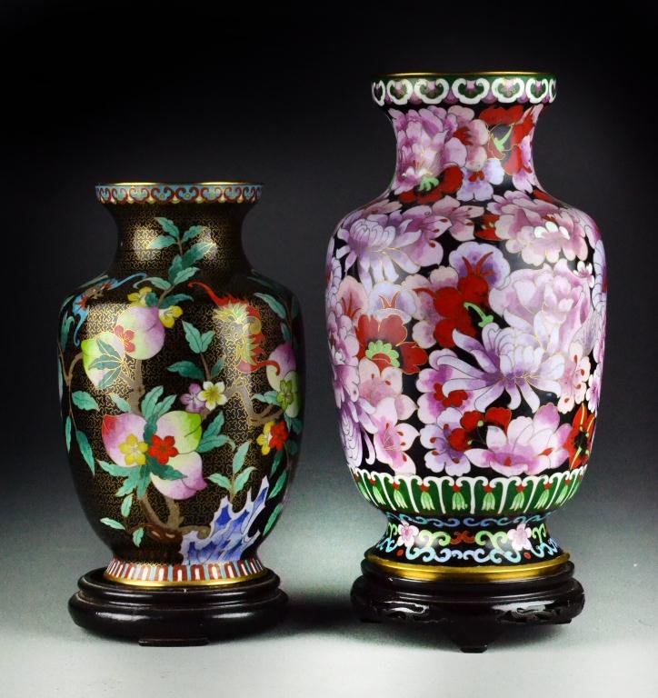 (2) Chinese Cloisonne Vases with Stands: To include a large baluster shaped vase decorated with pink floral decoration having aqua interior along with smaller black vase decorated with bats, onions and peaches, having cobalt blue interior, l