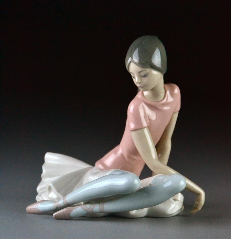 Lladro Porcelain Figurine "Pink Ballerina": "Ballet Ensaya Rosa" #1.357 depicting a seated ballet dancer with pink top, 6.5" H x 7" W, excellent condition in original box. Estate of Eugenia Sager, Plymouth, Michigan.