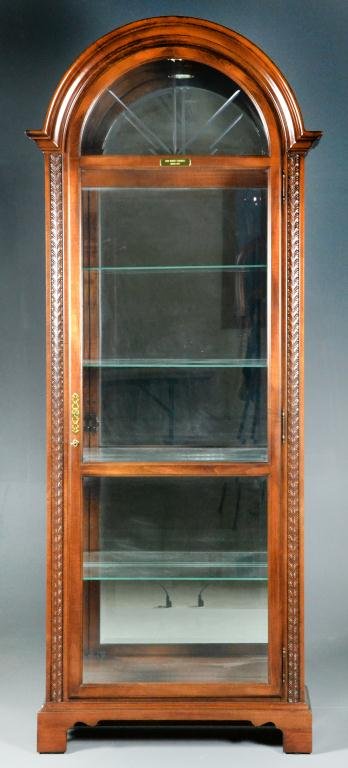 Howard Miller Mahagony Curio Cabinet: Curved pediment with molded cornice, interior light, five glass shelves, brass lock and escutcheon, raised on bracket feet, 84.5" H x 34" W x 15" D, circa 20th century, excellent condition. Estate of 