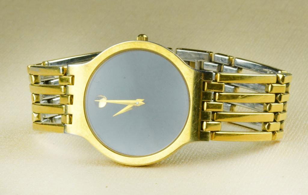 Movado Swiss Men's Goldtone on Stainless Watch: Having black face, Swiss movement, goldtone with extra links and Movado Authenticity card, circa 20th century, minor wear to gold. Private collection of Rochester Hills, Michigan lady.