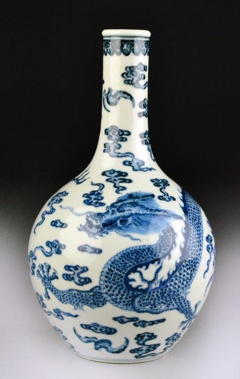 Chinese Blue & White Porcelain Vase: The bottle form vase finely painted to depict a five clawed dragon amongst ruyi clouds and bats chasing a flaming pearl, raised on short foot ring the base bearing Qianlong seal mark in underglaze blu