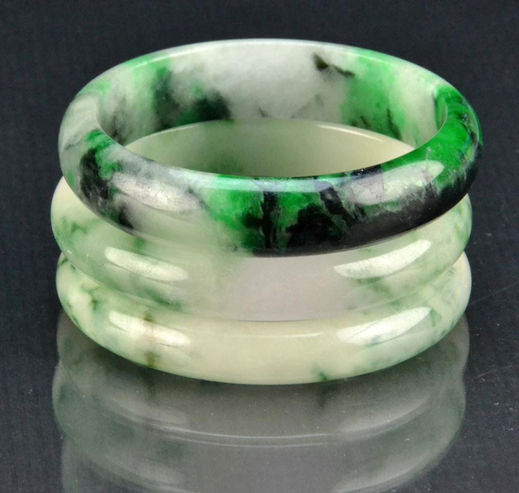 (3) Chinese Jade & Jadeite Bangle Bracelets: All with molted colors ranging from white to deep green with some black inclusions, all very well polished, average diameter 2.75". Important Grosse Pointe Shores Michigan Collection.