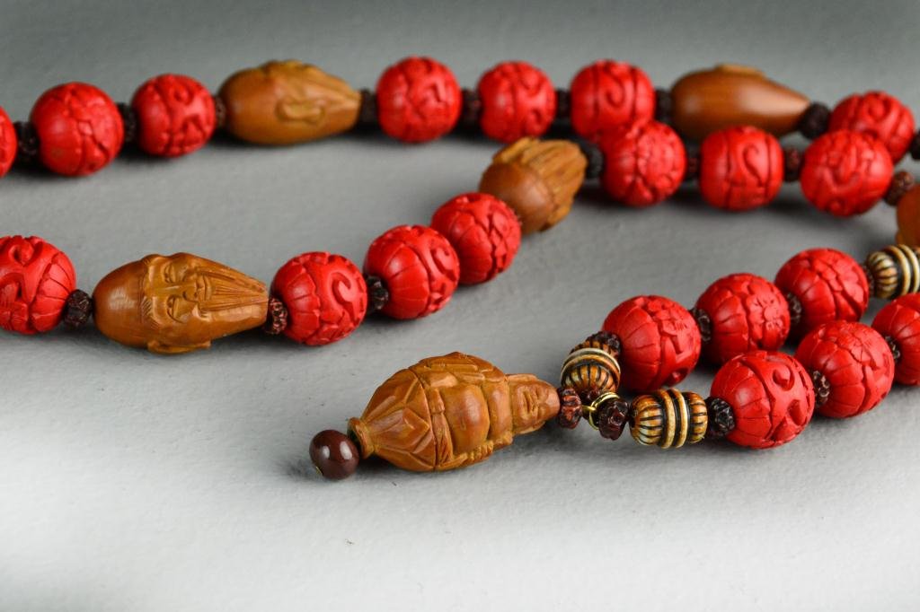 Chinese Carved Bead Necklace: With simulated carved cinnabar and carve nuts as heads, 26.5"L, circa 20th century. Private collection of a gentleman.