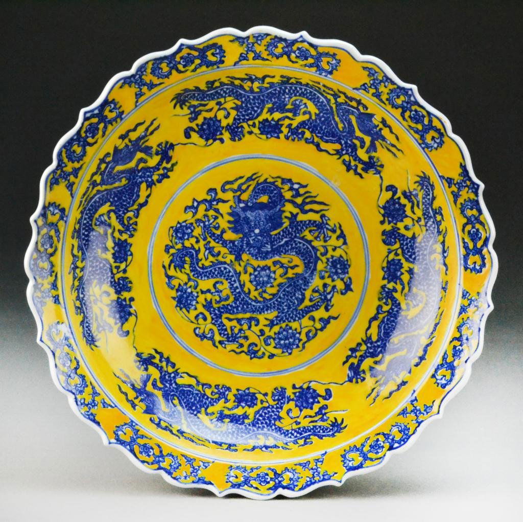 Chinese Qing Blue & Yellow Lotus Charger: Of lotus form finely painted to depict five clawed dragons amongst lotus blossoms and scrolling tendrils, raised on short foot ring, the base bearing Yongzheng seal mark in underglaze blue, 2.5"H X 12