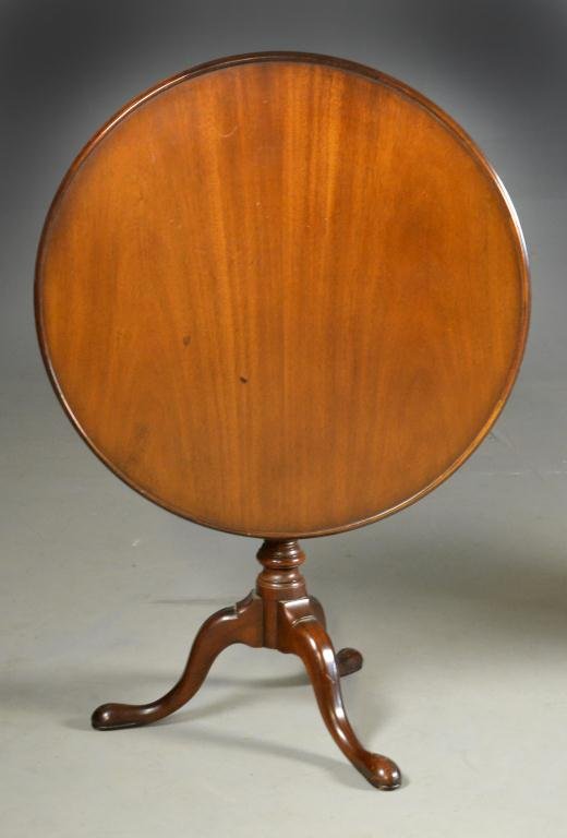 An American Tilt-top Mahogany Table: Circular top with molded edge, raised on birdcage with 4 turnings, above an urn-shaped turned pedestal and raised on four snake feet, 28" H x 31.5" Diameter, circa late 19th-early 20th century, some b