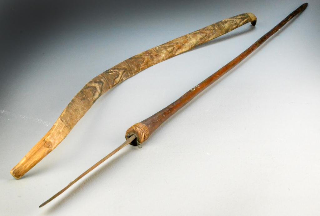 (2) South American or Oceanic Weapons: Includes one wood bow and one spear with wood handle and metal blade, woven wrap at intersection of blade and handle, spear measures 61.5" L, bow measures 47" L, circa late 19th-early 20th century Con