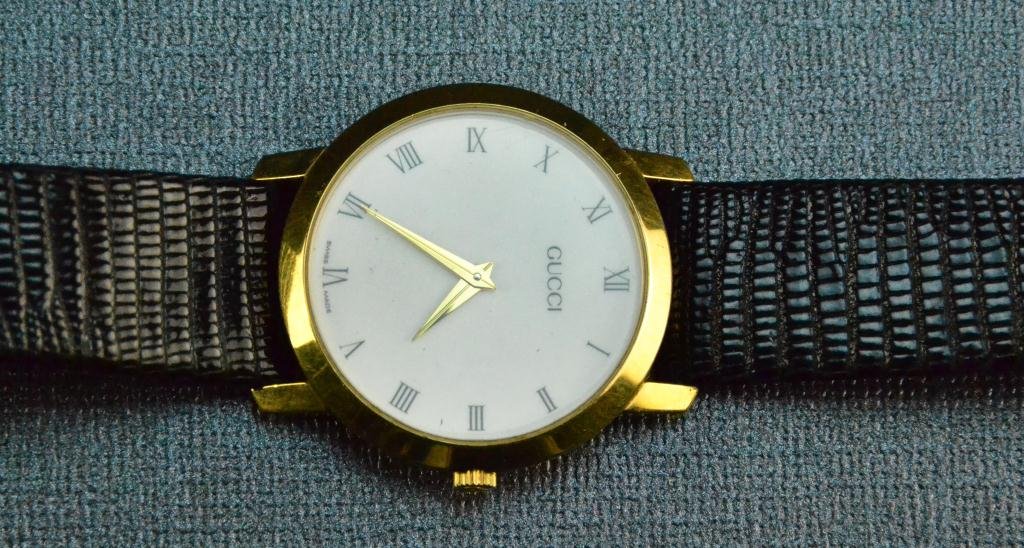 Gucci Watch with Genuine Lizard Band: Swiss Made, Case reads Gucci 2200M, black band stamped genuine lizard, case measures 1.25" diameter, circa late 20th century Condition: Good, working condition unknown Private collection Fort Gratiot,