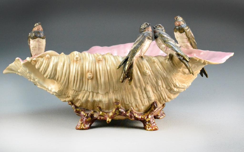 Rudolstadt Porcelain Shell Bowl: Depicting large polychrome conche shell raised on coral style feet, rim having four swallows perched on edge, marked to bottom with blue RW within diamond beneath a crown and impressed No. 3217, 8" H 