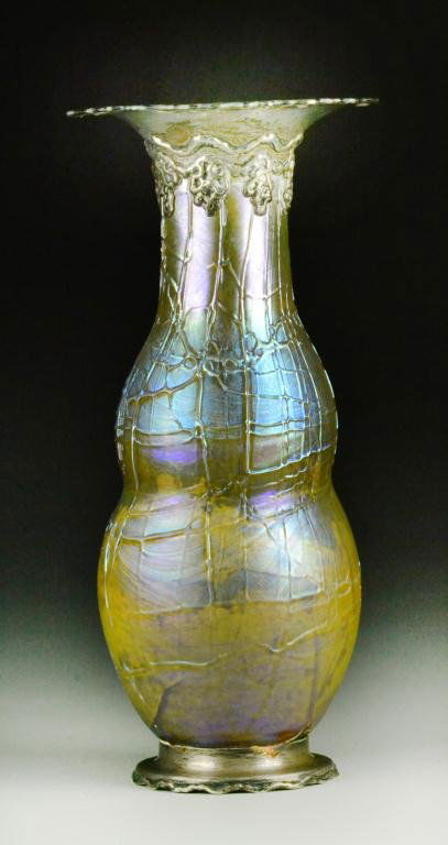 A Rare Tiffany Cypriot Lava Glass & Sterling Vase: Iridescent thread-like applied glass decoration on gourd-shaped vase, sterling silver elaborate rim and foot with scroll decoration, with polished pontil, signed to sterling base 'Tiffany & Co. Makers