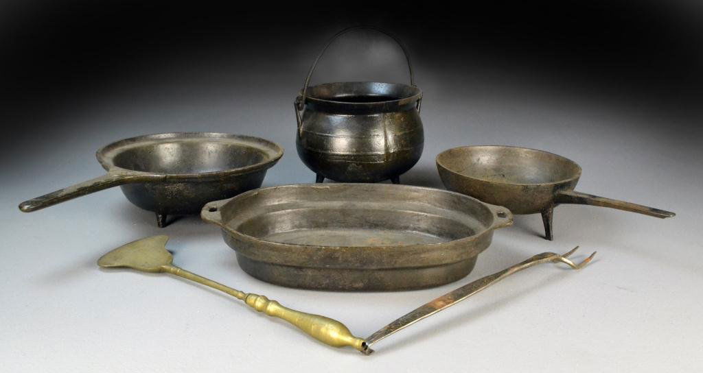 6 Pieces American Cast Iron Including Posnet Pots: To include one round pot with bail handle raised on three tapered feet 6" H x 9" Dia., two 3-legged hearth frying pans, one 3.5" H x 14" L x 7.75" Dia., the other 3.75" H x 17" L, x 10" Dia., oval bak