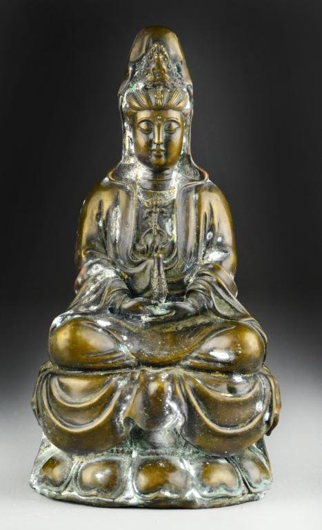 Chinese Bronze Gaunyin: Finely cast as a seated Guanyin holding a vase raised on lotus throne, bearing Ming Xuande mark to base, 9"H. Private collection Rochester Hills Michigan.