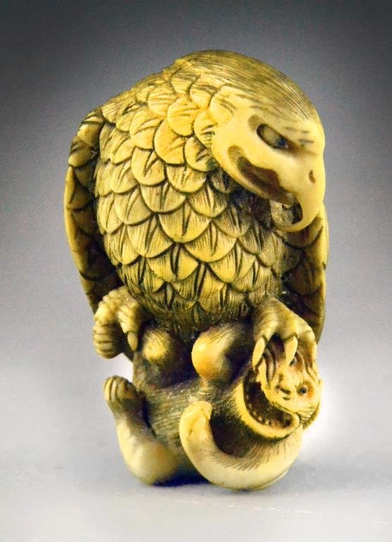 Fine Japanese Ivory Netsuke By Kano Tomokazu: Exquisitely rendered carving depicting an eagle holding a monkey in his talons, with two character signature for Tomokazu to bottom, Kano Tomokazu(circa 1765-1840), was born in Kijimachi, Gifu. When h