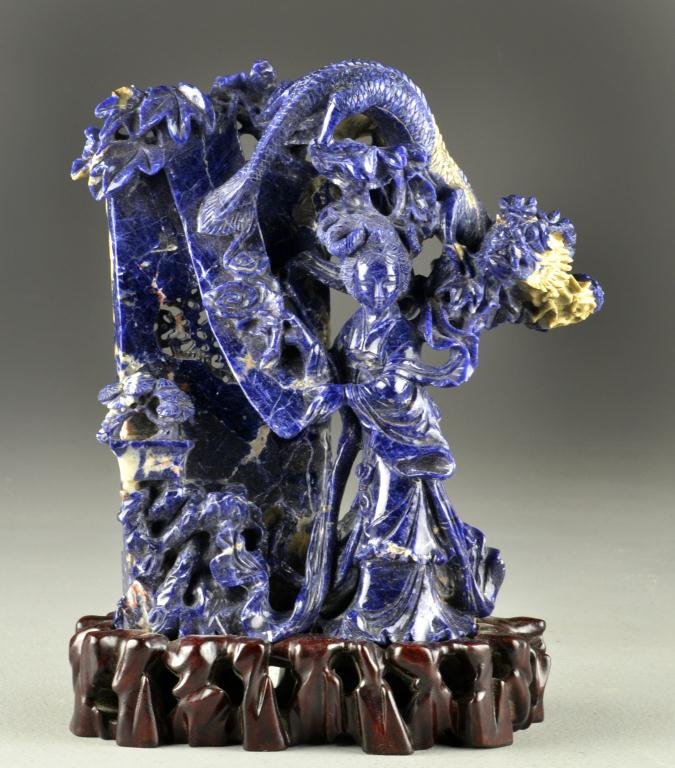 Chinese Carved Sodalite Figural Sculpture: Depicting Guan-Yin and dragon, raised on rosewood stand, 9" H not including stand, circa early-mid 20th century. Property from Ethel Miller Siegel Trust, Bloomfield Hills, Michigan.