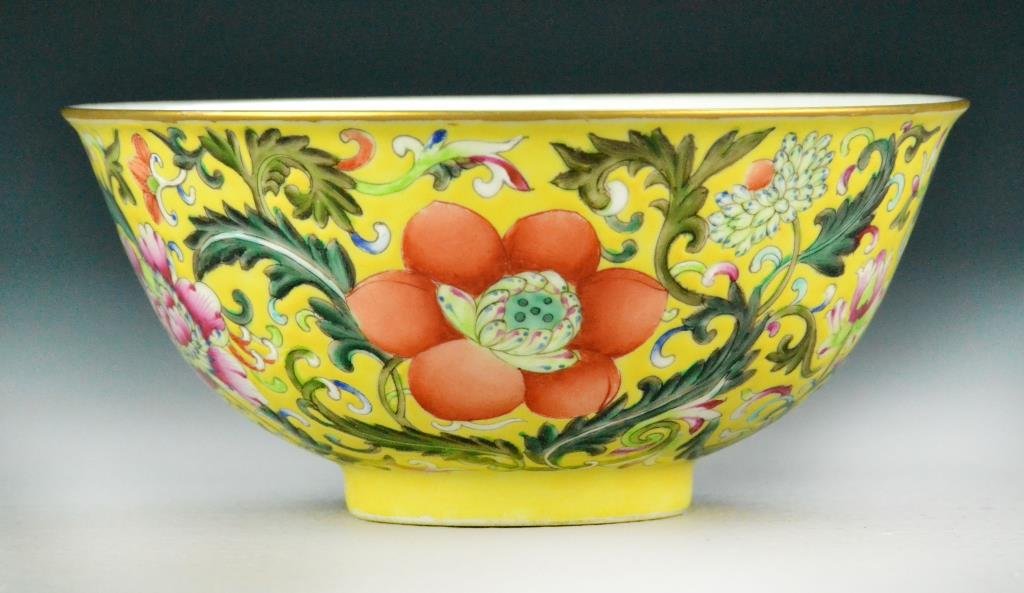 Chinese Famille Rose Porcelain Bowl: Finely enameled floral and tendril decoration on yellow ground, gilt rim, five iron red bats to interior, underglazed iron red Qianlong sealmark to bottom, 2.5" H x 5.5. Condition: good. Property of B