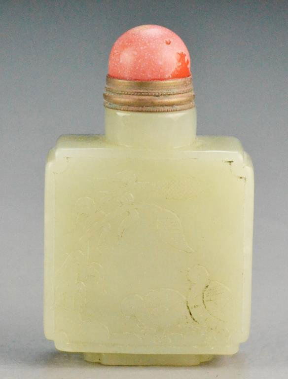 Chinese Qing Celadon Jade Snuff Bottle: The celadon almost white jade snuff bottle finely carved to one side to depict a rat and coins, the reverse carved as birds and flowers, 3.75"H, circa late 19th/early 20th century. Property of a Houst