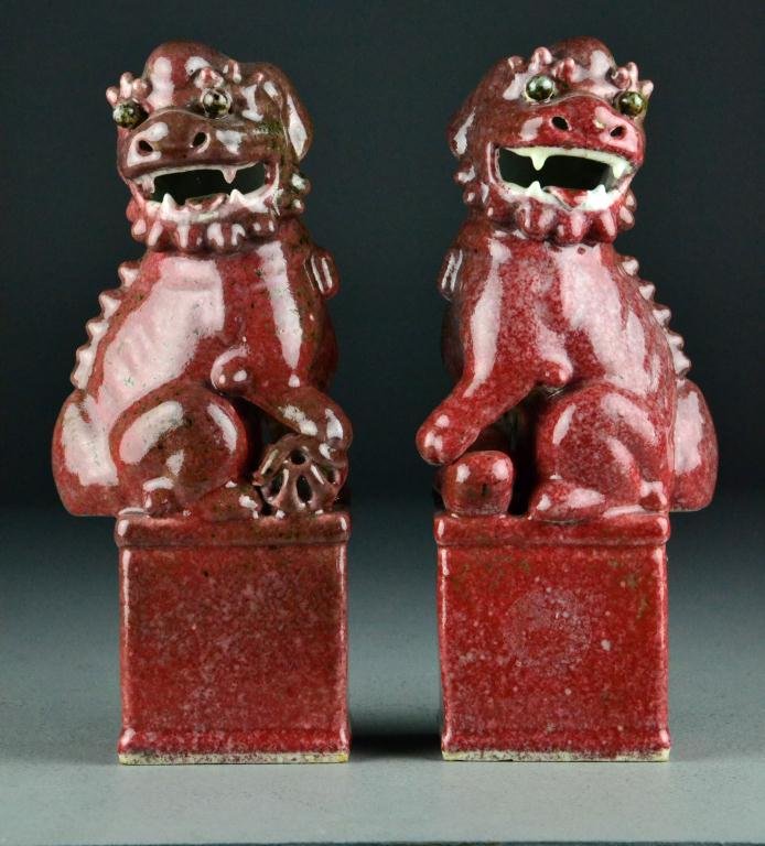 Pr. Chinese Qing Porcelain Foo Dogs: Finely molded with strawberry glaze to depict two foo dogs on pedestals, one marked "CHINA" in blue on bottom,10.25"H, circa late 19th/early 20th century. Important West Bloomfield Michigan Collection