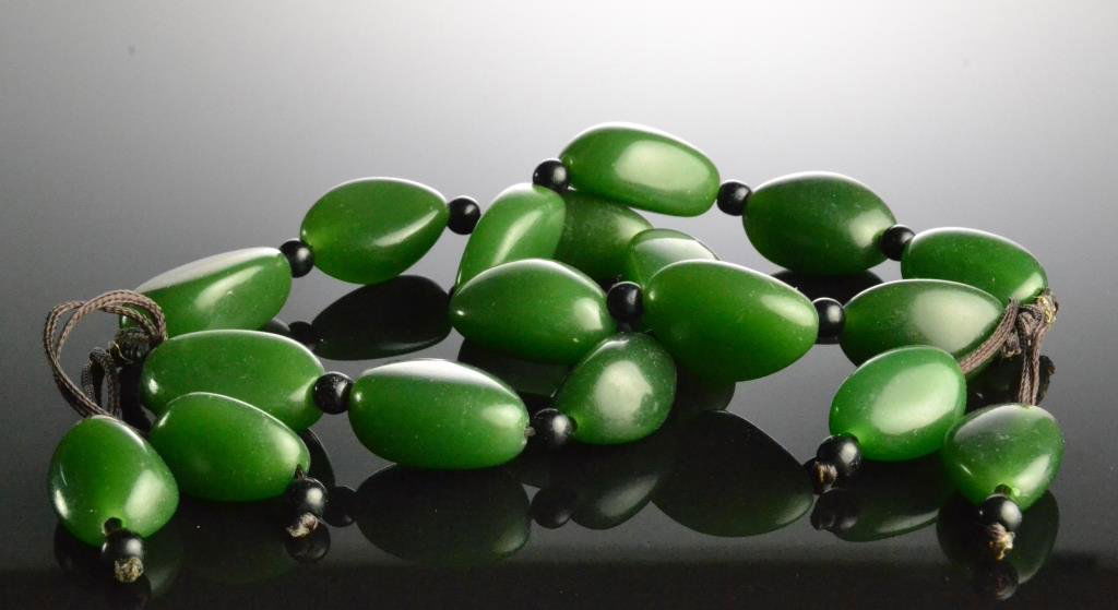Pr. Chinese Jade Bead Bracelets: Each consisting of nine green jade pebbles hung from brown cord, each pebble measures approximately 30.06mm long. Property of a Traverse City Michigan Gentleman.