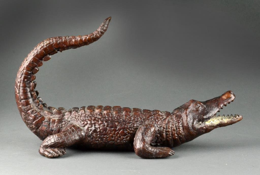 Signed Cast Bronzed Alligator Sculpture: Finely cast to depict an alligator with open mouth and raised tail. Signed illegibly to base Sh? factory 14" L x 8" H to top of tail, circa 20th century. Condition: Very good The Trust of Ethel Siegel