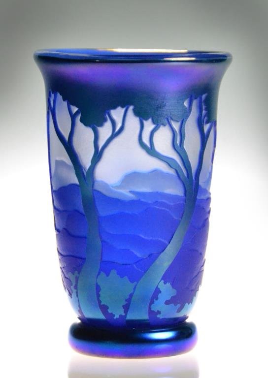 Dan Shura Orient & Flum Cobalt Cameo Glass Vase: Tumbler-shaped vase with gently flaring rim, multi-layered blown and etched opaque cobalt, irridescent blue and clear cameo carved glass, depicting rolling hills through tall trees, signed in glass to