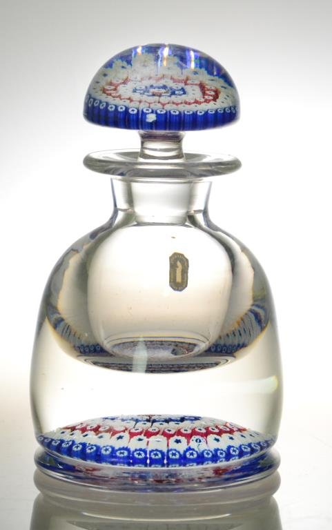 Whitefriars Millefiori Glass Bottle with Stopper: Depicting red, white and blue millefiori decoration on inside bottom and in stopper, 5.5" H, Made in England, with original paper tag, circa 1980. The Trust of Ethel Siegel, W. Bloomfield, Michigan.