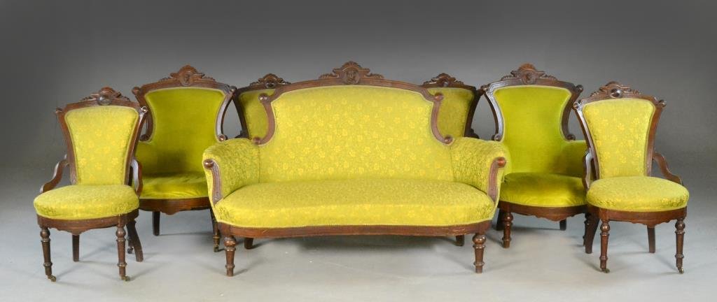 (7) Pc. Eastlake Settee & Six Carved Chairs: Nicely carved parlor set, couch and 4 chairs with carved bas relief head in medallion on crests, all with elaborate scrolled carving, two armchairs in light green velvet; settee and remainder of set i