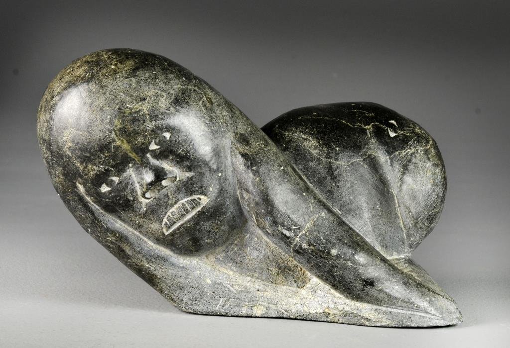 A Wonderful Carved Soapstone Inuit Sculpture: Depicting an Eskimo and seal, numbered to bottom, the stone black in color with finely carved details and good polishes, a very heavy sculpture measuring 9.75"H, circa early to mid-20th century. Priva