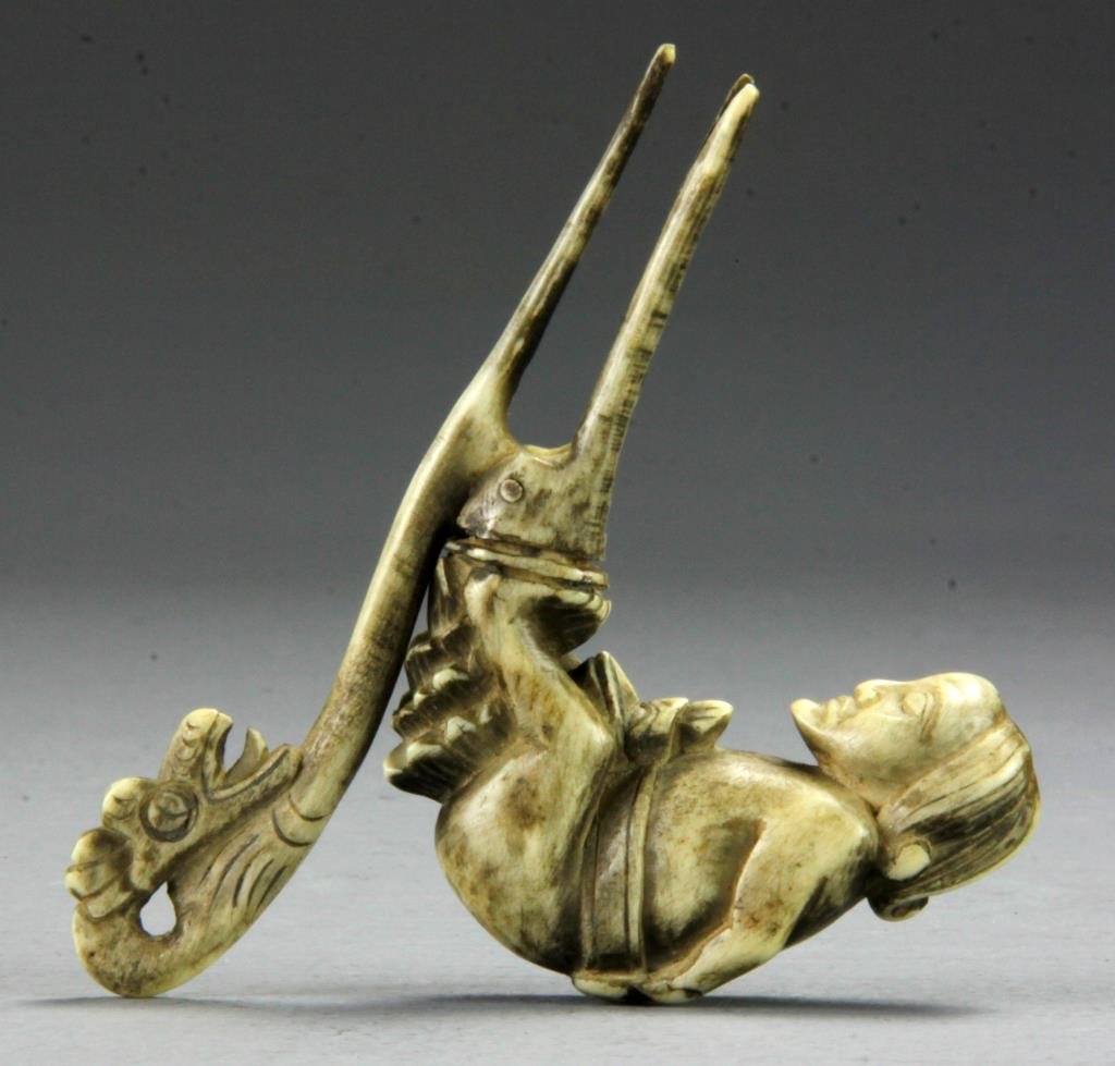A Finely Carved South American Ox Bone Hair Piece: Carved to represent four figures, including a female, a bird head, a swordfish, and a dragon, 4.75"L, circa late 19th/early 20th century. Provenance: Formally in the collection of Gary Culpepper of Cu