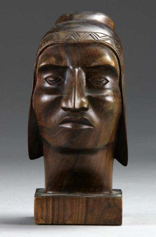 An Antique South American Carved Wood Bust: Depicting a tribal man with head piece having finely carved details and an attractive old surface, 8"H, circa early 20th century. Provenance: Formally in the collection of Gary Culpepper of Culpepper 
