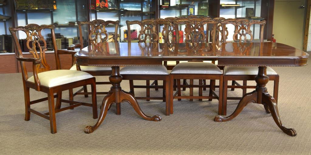 A Nine Piece Chippendale Style Mahogany Dining Set: Having a rectangular table with finely carved beaded apron raised on two tripod bases, having carved ball and claw feet, having two arm chairs and six side chairs, having fancy carved wood splats, rai