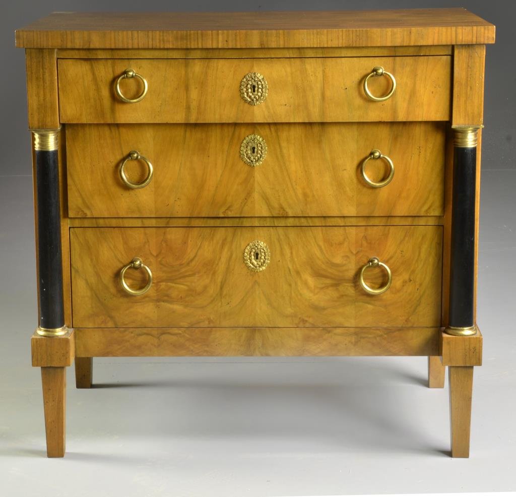 A Baker Neoclassical Style Three Drawer Chest: Having ebonized wood pillars, three graduated drawers, having it's original lock to top drawer, 32"H X 33"W X 19"D, circa 20th century. Condition: Circa early 20th century.