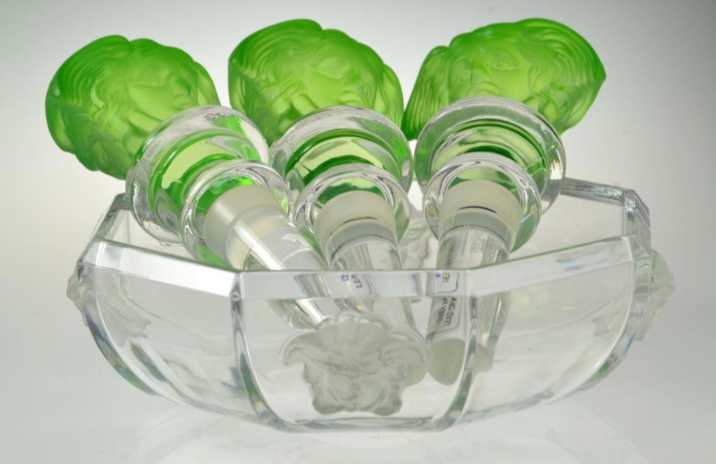 (4) Pcs. Versace Glass: To include three apple green and clear glass figural bottle stops, together with a clear glass faceted bowl with molded figural appliques, all in original boxes, bowl is 5.5"D. Provenance: Formally in