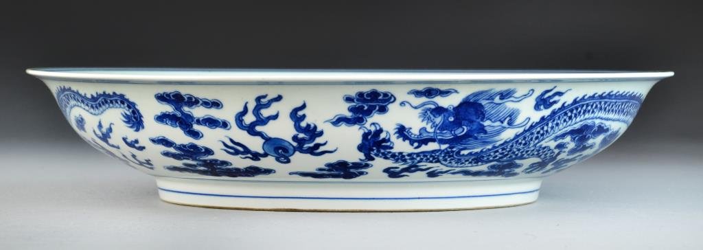 Chinese Blue & White Porcelain Basin: Depicting five clawed dragons contesting flaming pearls amongst ruyi clouds, with slightly flared rim, raised on short foot ring, the base bearing six character Yongzheng mark within two concentric ci