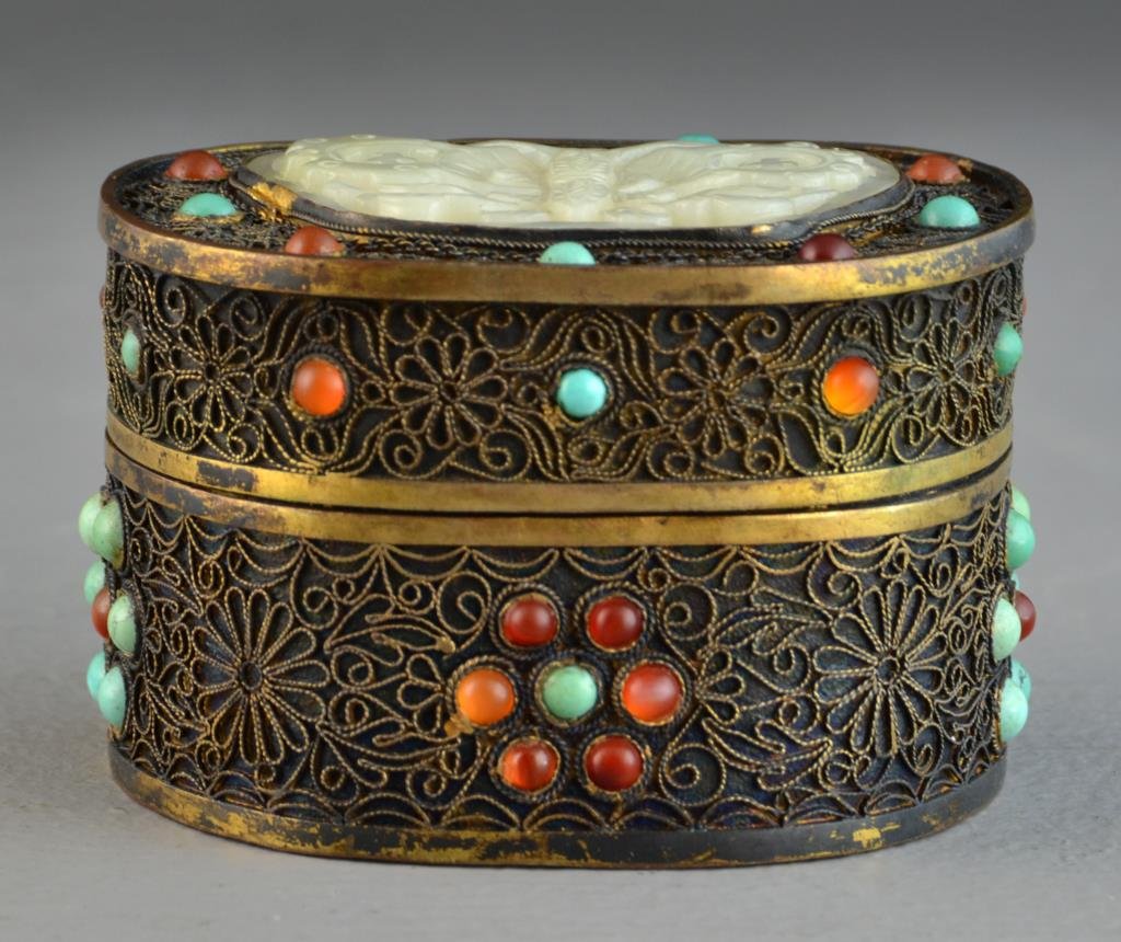 Chinese Jade Inlaid Filigree Trinket Box: The inset white jade plaque finely carved to depict a butterfly with swastikas on it's wings, the box with inset stones of turquoise and agate, 2.25"H X 3.25"D, circa early 20th century. Property of a