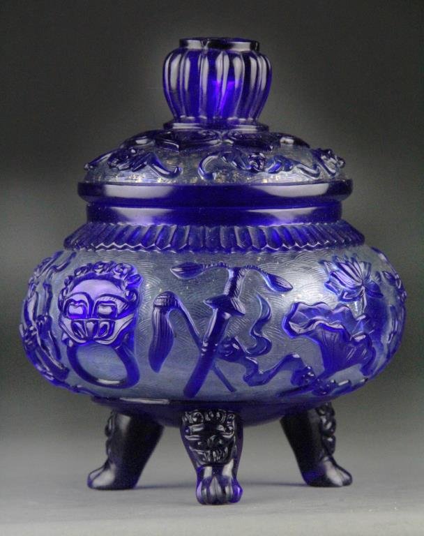 Chinese Peking Glass Covered Jar - Cobalt/Clear: Covered bulbous footed jar having cobalt blue overlay over clear ground with gold flecks, body carved with many treasures and raised on three claw feet, Shou symbol on knob finial with five bats on li